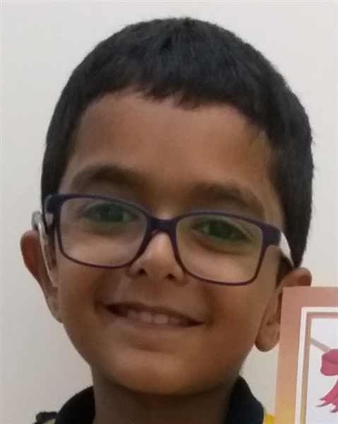 Picture of an 8 year old boy with Usher syndrome wearing hearing aids and eyeglasses